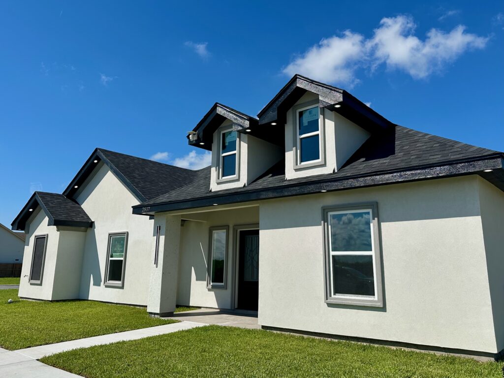 A single family home completed construction under a cloudy blue sky.