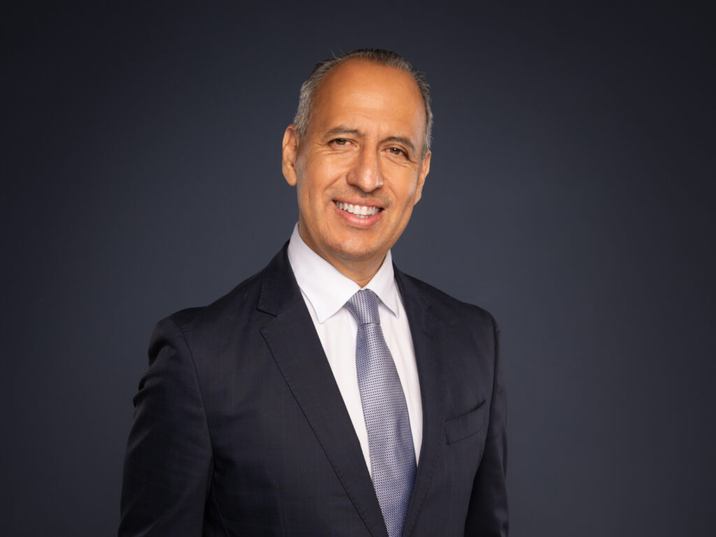 Ramiro Garza | Owner, Publisher of the Rio Grande Valley Business Journal, in a suit, white shirt and grey tie.