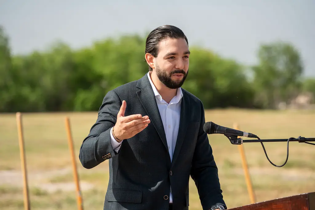 Luis Rodrigo Castillo stands at a podium speaking into a microphone during the groundbreaking of his $50 million industrial park in Mission, Texas.