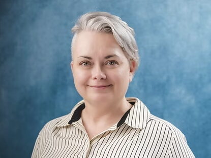 Portrait of Melinda Gomez, the new Rio Grande City Economic Development Director, wearing a striped blouse in front of a blue studio background.