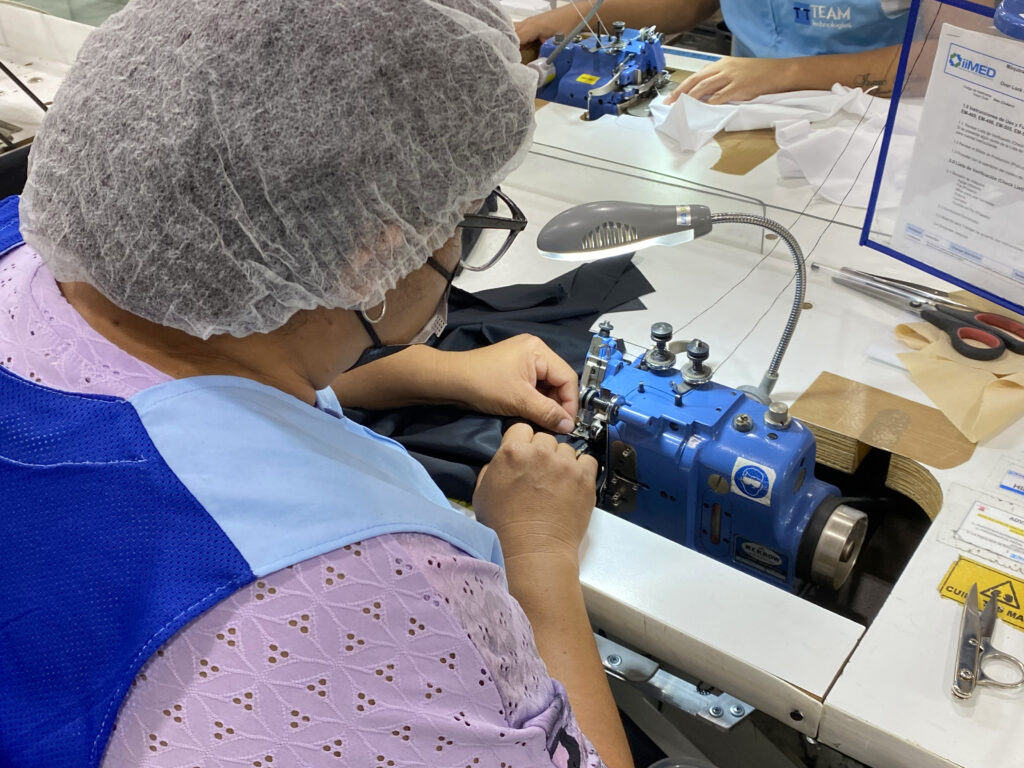 Close-up of a maquiladora worker using a sewing machine to produce garments in Reynosa.