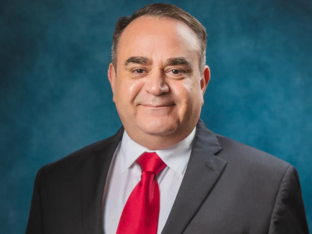 Rosbell Barrera in a black suit and red tie. 