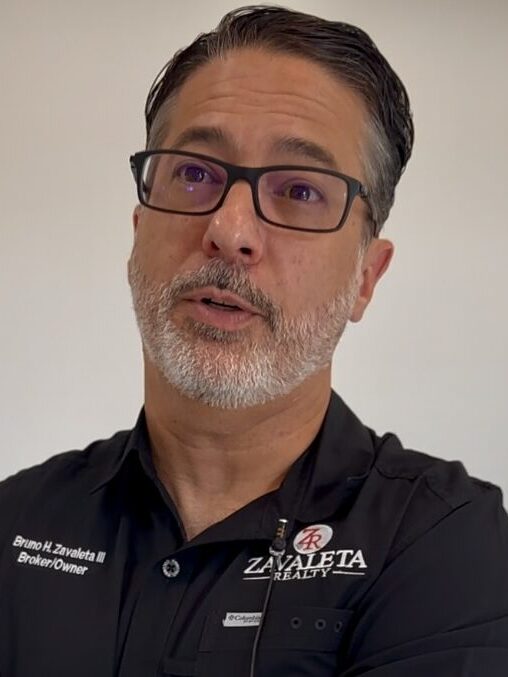 A man wearing glasses and a white beard with a black shirt.