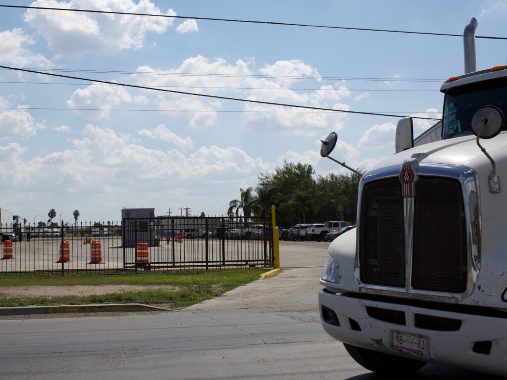 A commercial tractor trailer pulls out a produce warehouse area.