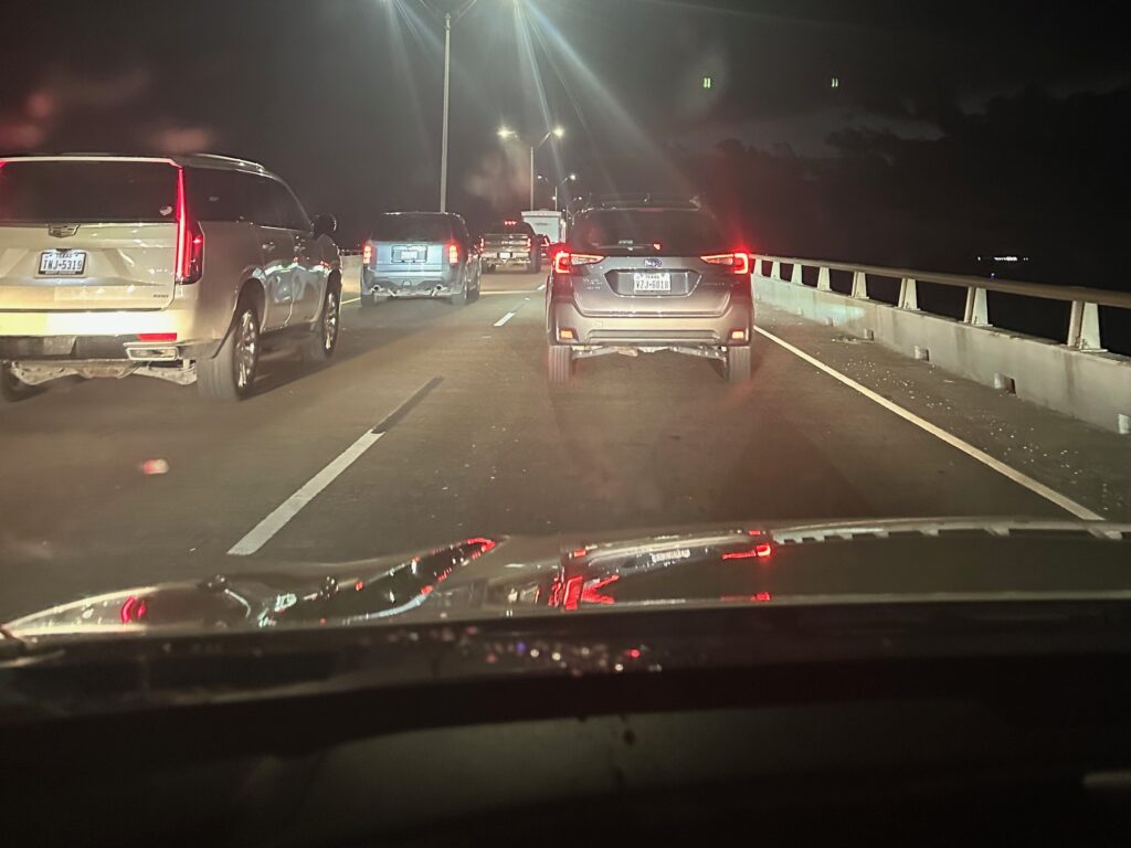 Cars lined up on the Queen Isabella Memorial Causeway at night, brake lights glowing in heavy traffic.