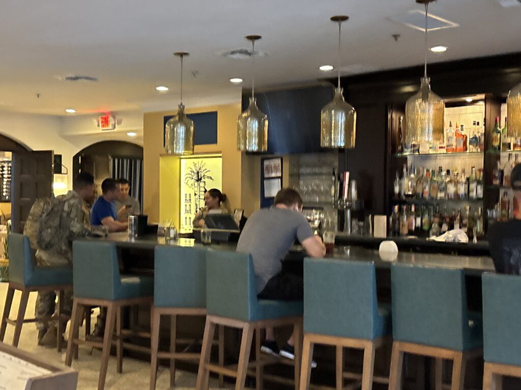 Guests, including soldiers, sit at the hotel bar at Casa de Palmas in McAllen.