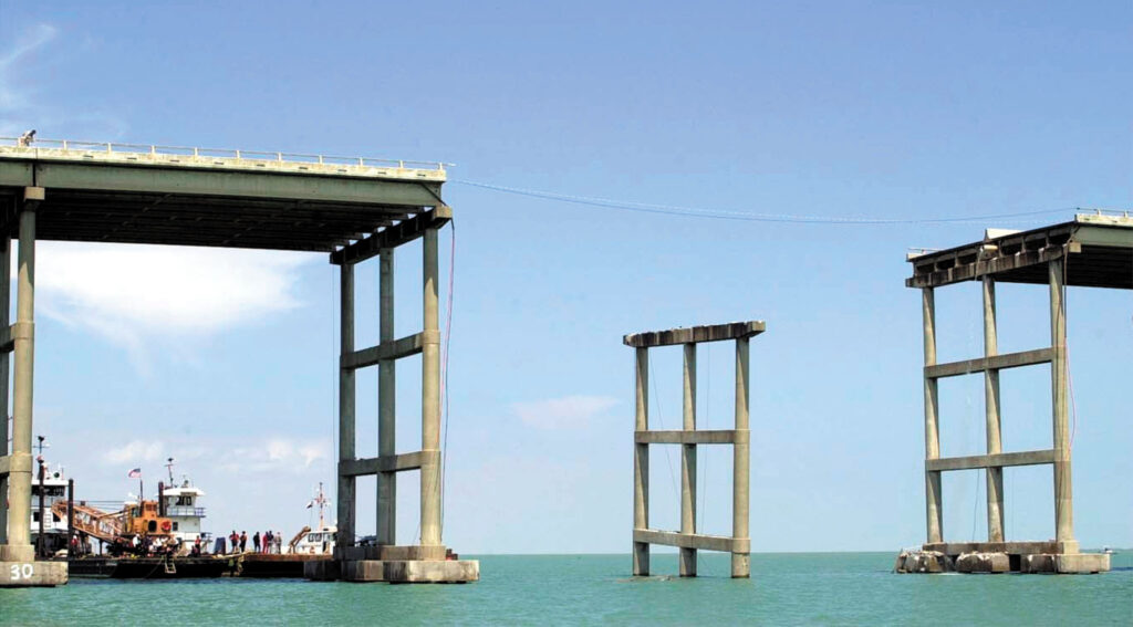 Partially collapsed sections of the Queen Isabella Memorial Causeway spanning turquoise water after a 2001 barge collision.
