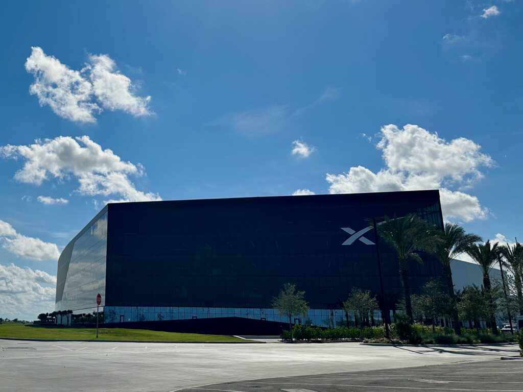 The outside of SpaceX's headquarters in Starbase, Texas beneath a blue sky.