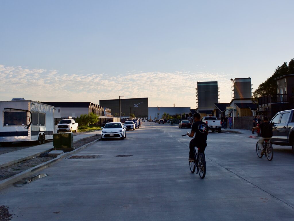 bicyclists ride on a sidewalk looking at their phones