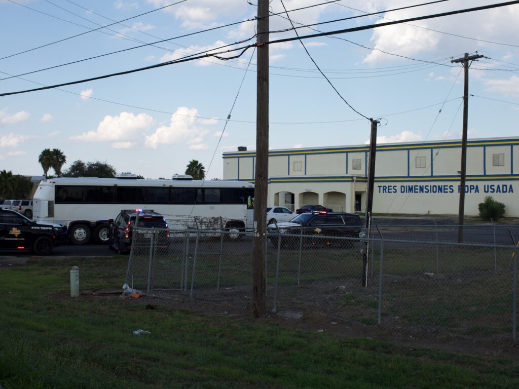 A white bus enters a property.