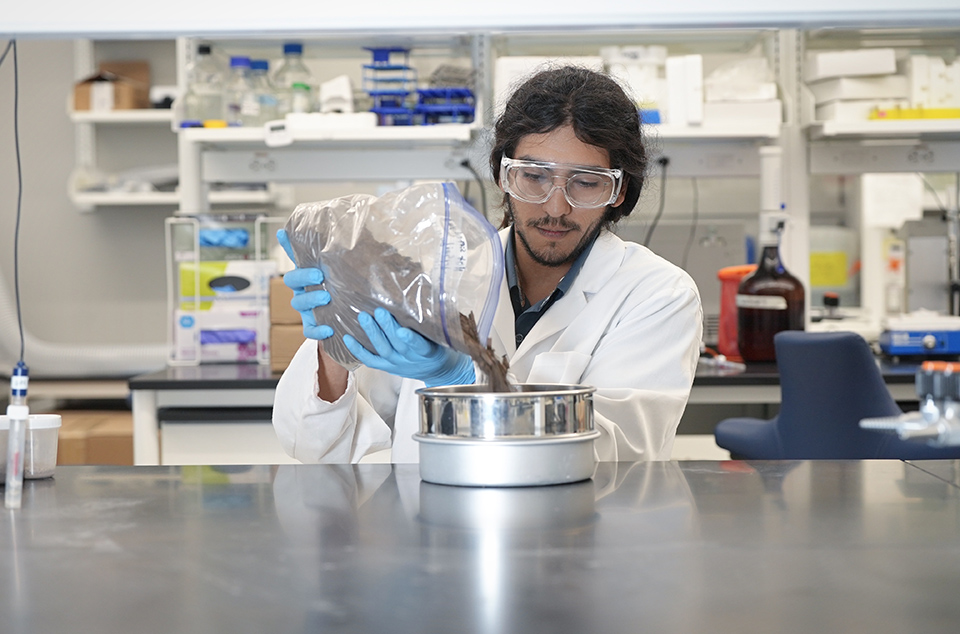 Graduate student Angel Salinas pours soil samples into a sieve in a UTRGV laboratory on the Edinburg campus.