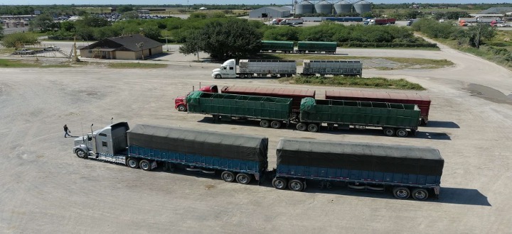 Aerial view of double-trailer trucks parked in a commercial lot near the Progreso International Bridge.