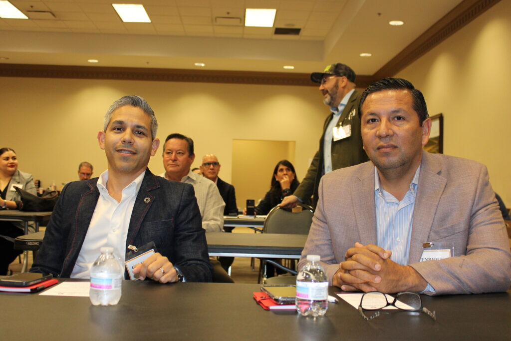 Gerardo Martínez y Enrique Ramos, sentados a una mesa durante el foro binacional de inversión de la EDC de Weslaco.