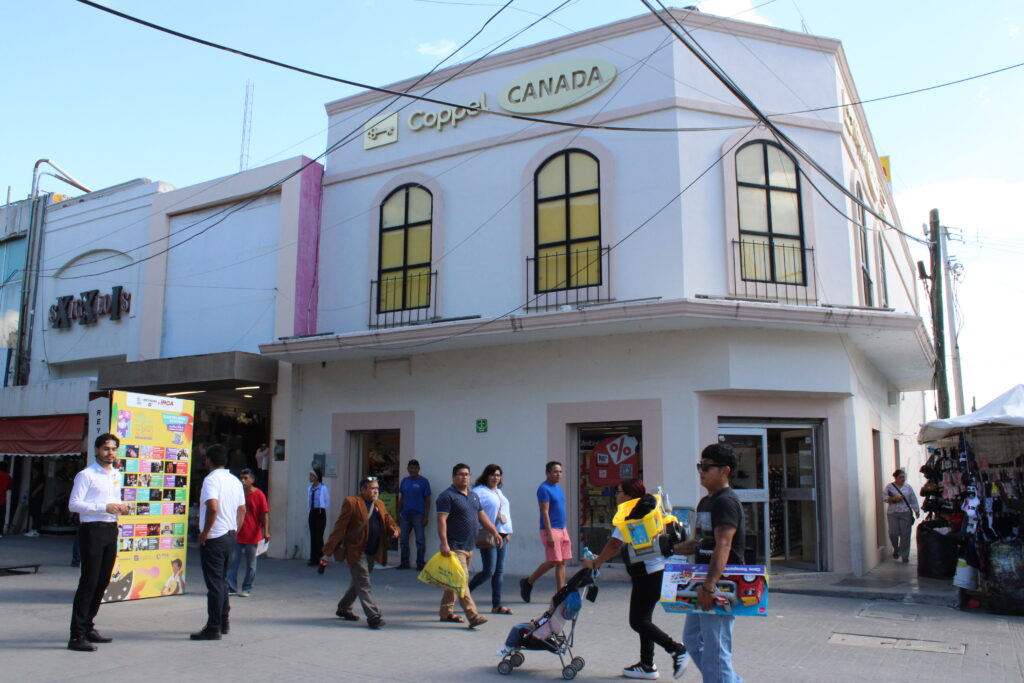 People walk near a Coppel store in Reynosa’s downtown shopping area during El Buen Fin.