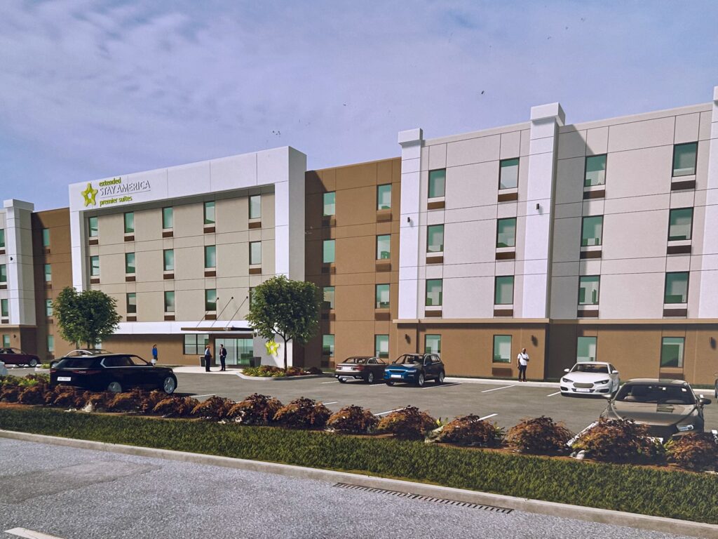 Rendering of the planned Extended Stay America Premier Suites hotel in Harlingen, showing a four-story tan and white building with parking spaces in front.