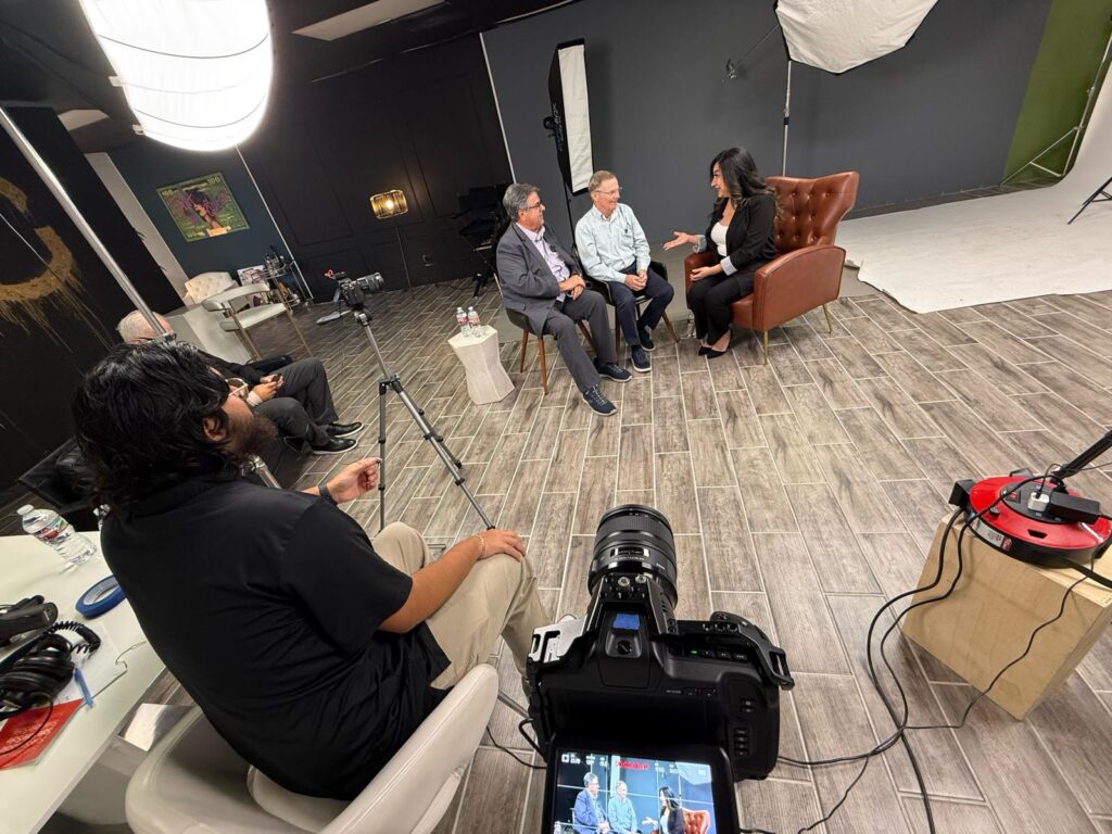 Behind-the-scenes view of the RGV Business Journal podcast recording, showing Managing Editor Naxiely López-Puente interviewing Brian Godinez and Jim Darling about infrastructure and regional growth in the Rio Grande Valley.