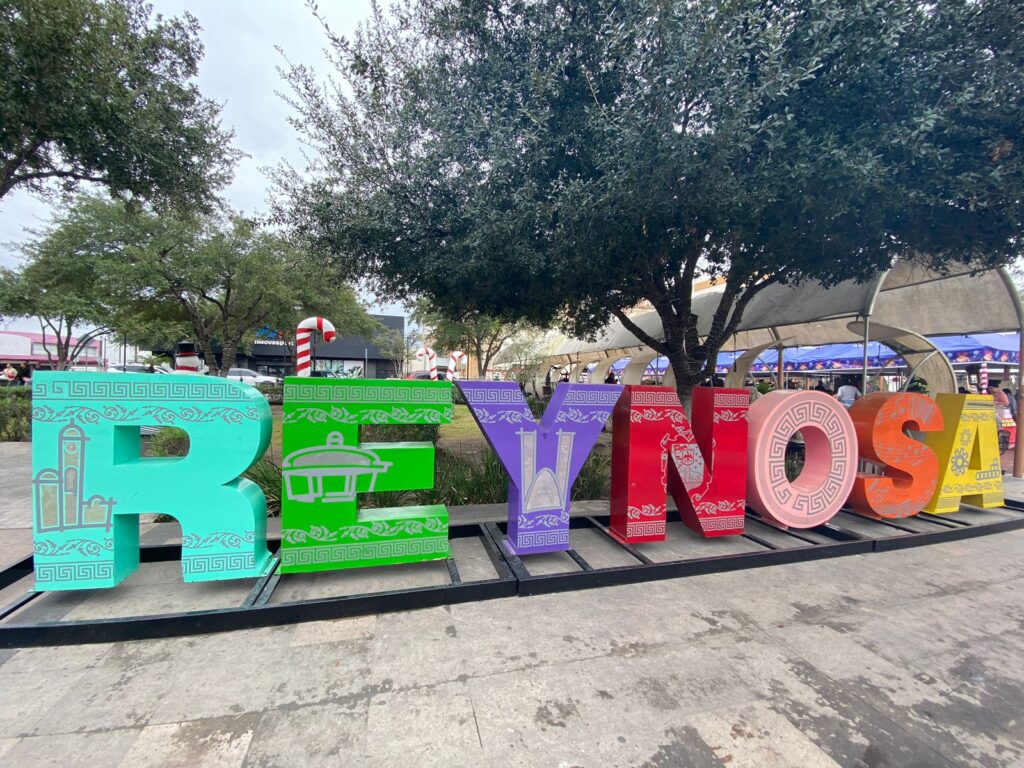 Large colorful “Reynosa” sign displayed in the city’s main plaza with holiday decorations in the background.