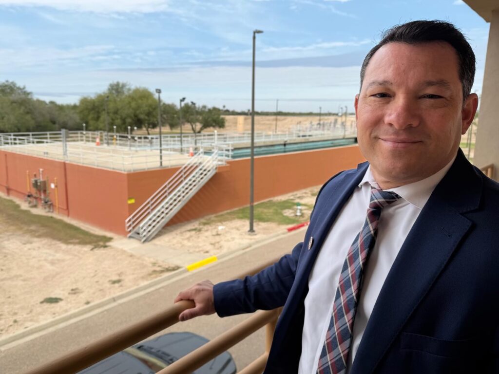 Mark Vega standing on a balcony with the North Water Treatment Plant visible behind him.