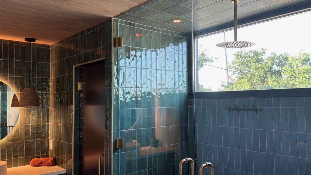 Cuarto de baño moderno en el alojamiento de alquiler a corto plazo de Buji en McAllen, con paredes alicatadas y grifería con sensores.