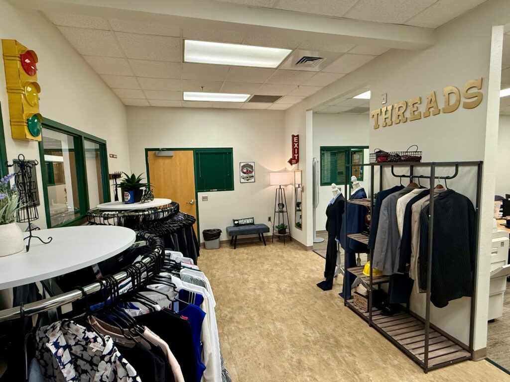 Interior view of South Texas College’s Threads Career Closet with racks of professional clothing and displays.