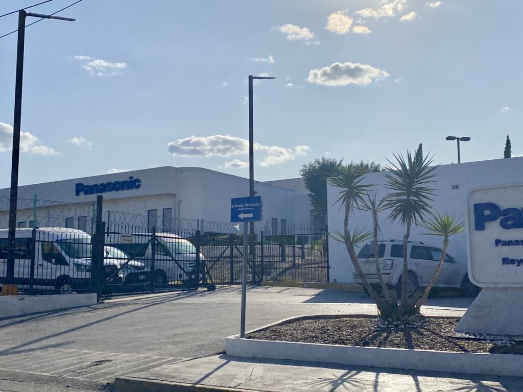 Entrance to Panasonic Automotive Systems facility in Reynosa with security fencing and company signage.