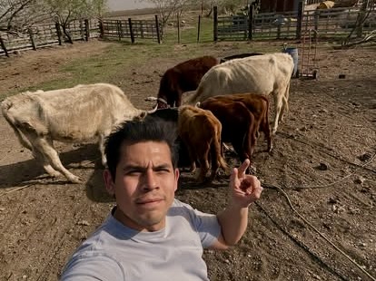 José Luis Pérez Miranda, de pie frente a unas vacas dentro del recinto de un rancho.