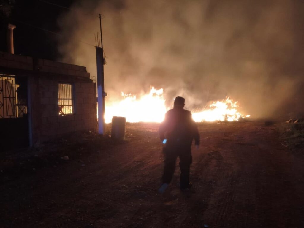 Un gran incendio ilumina el cielo nocturno mientras se registran incidentes de seguridad en la región.