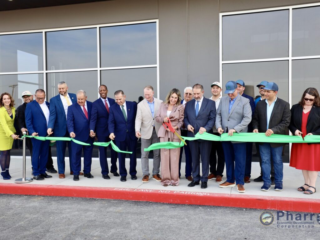 Group of local officials and business leaders cutting a green ribbon outside the new CIL Fresh refrigerated warehouse in Pharr during the facility’s grand opening ceremony.