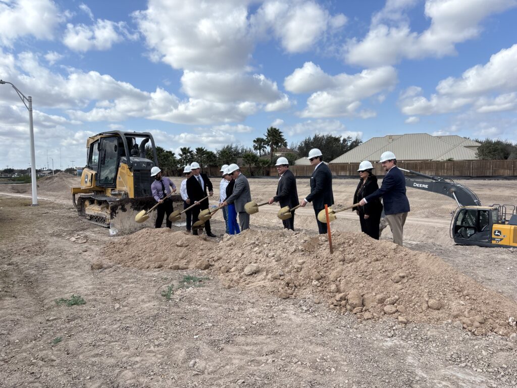 McAllen city officials stand near a drainage channel during a groundbreaking ceremony announcing a flood control and trail improvement project.