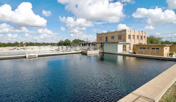 Water treatment facility in Brownsville with large basins and processing equipment under a blue sky, part of the city’s public utilities system.