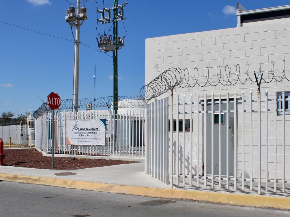 Gated entrance with fencing and signage at a logistics warehouse facility in Reynosa.