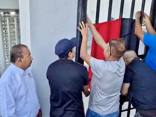 Trabajadores colocando banderas de huelga rojas y negras en unas instalaciones de Trico en Matamoros tras el cese de las operaciones.