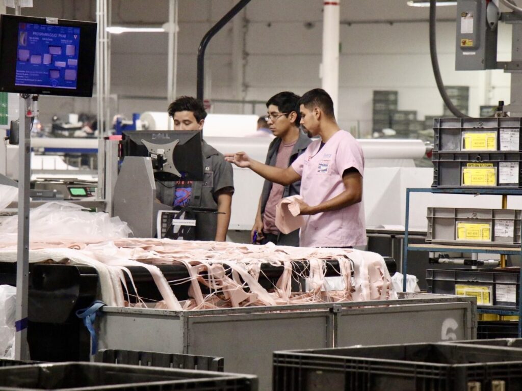 Trabajadores que manejan maquinaria en el interior de una planta de fabricación en Matamoros vinculada a las operaciones de Trico.