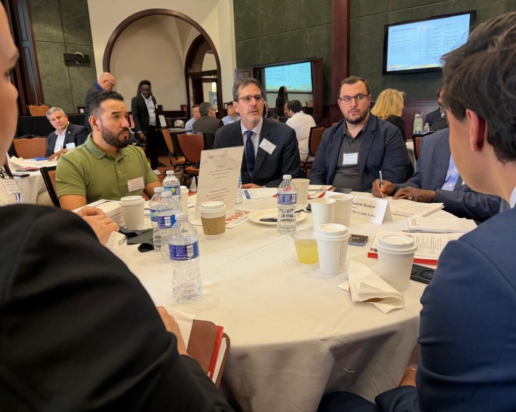 Group of professionals in discussion at a roundtable during a UTRGV manufacturing symposium.