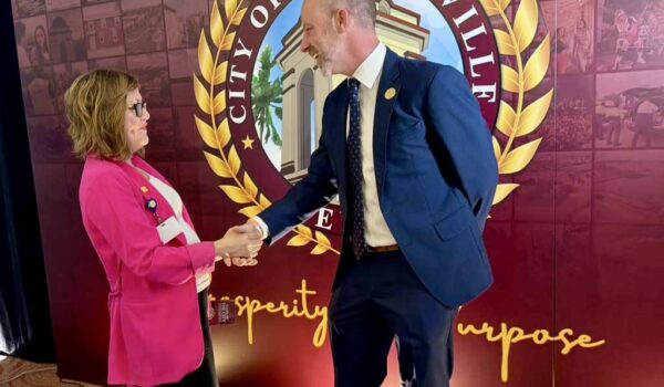 Brownsville Mayor John Cowen Jr. shakes hands with Yvette Padilla of Driscoll Children’s Hospital in front of a City of Brownsville backdrop at a reception event.