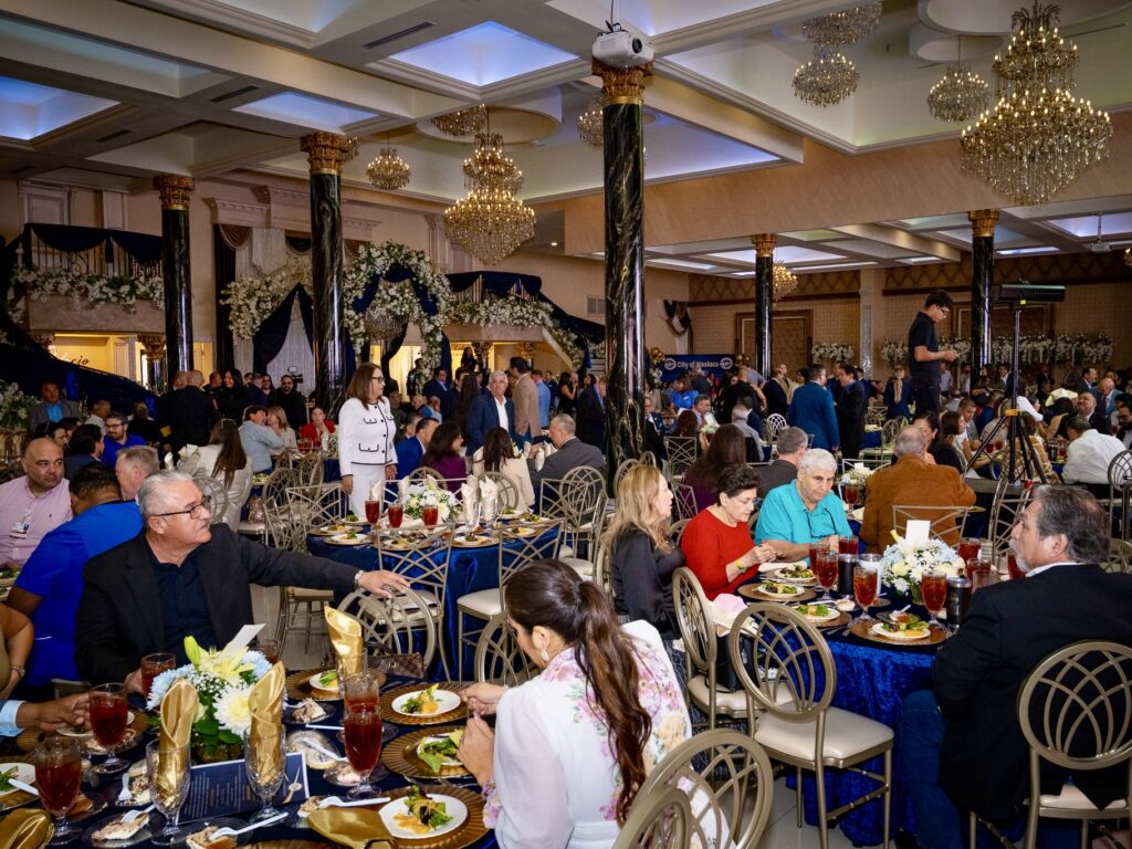 Large crowd seated at banquet tables during Weslaco’s State of the City event in a decorated ballroom.