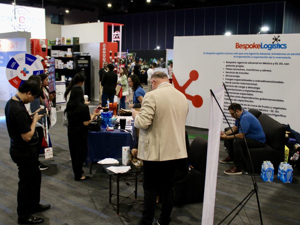 Los asistentes recorren el recinto ferial de Reynosa, visitando los stands de empresas de logística y servicios durante una feria de proveedores.