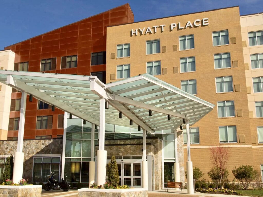 Representación de un hotel Hyatt Place que presenta un exterior moderno con una marquesina de cristal en la entrada y una distribución de varias plantas, y que forma parte de un proyecto hotelero previsto en Brownsville.