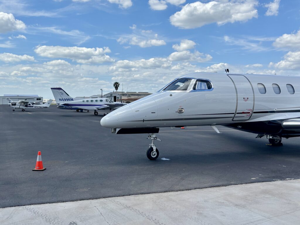Small aircraft parked on the tarmac at Mid-Valley International Airport under a blue sky.
