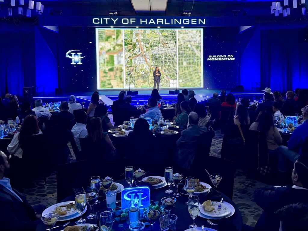 Los asistentes, sentados en las mesas del banquete, siguen una presentación durante el acto «Estado de la ciudad» organizado por el Ayuntamiento de Harlingen.