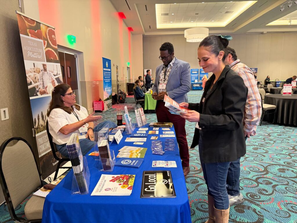 Small business owner Selina Jimenez speaks with exhibitors at a resource booth during the Texas Governor’s Small Business Summit in Mission.