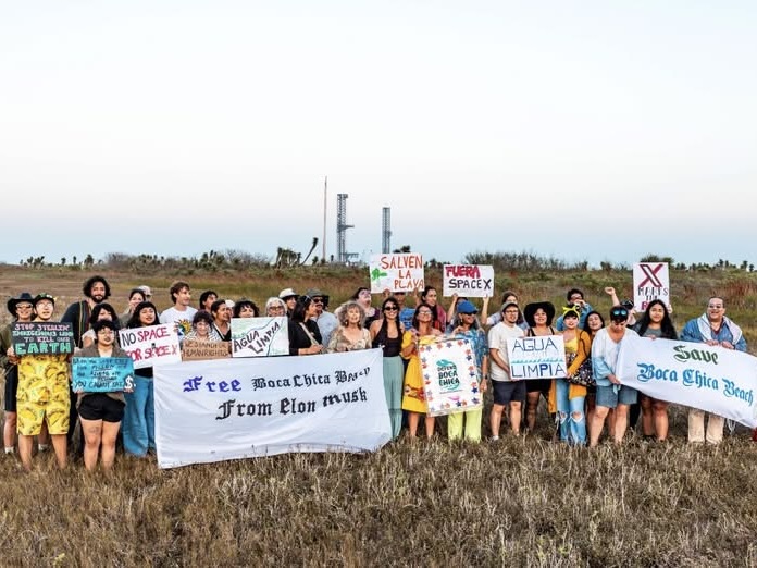 Environmental activists hold signs and banners opposing SpaceX near Boca Chica.
