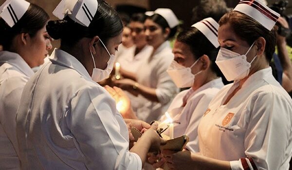 Nursing students at the Autonomous University of Tamaulipas participate in a ceremonial candle-lighting event as part of their nursing education.