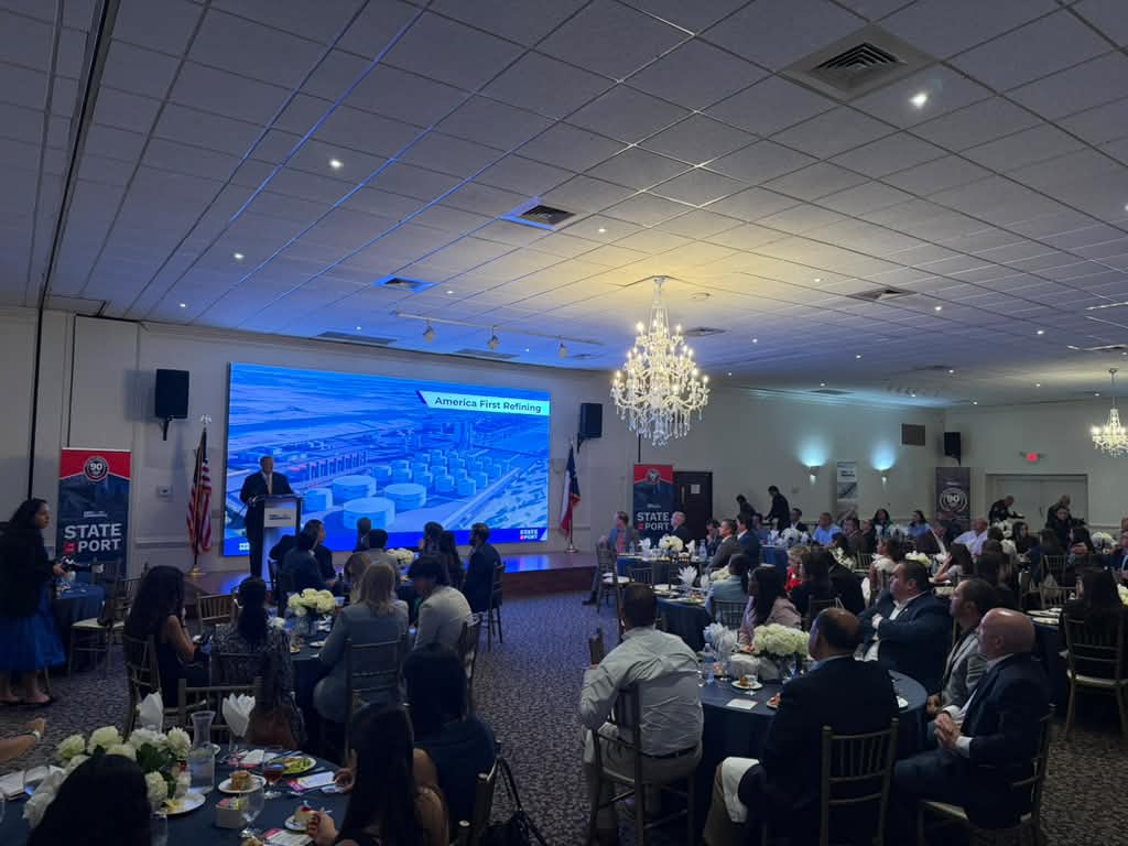 Business leaders, elected officials and community members attend the Port of Brownsville’s State of the Port event in a banquet hall while project renderings are displayed on a large screen.