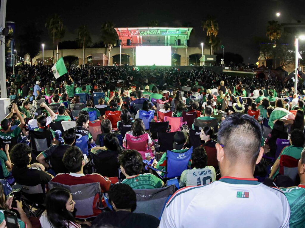Los aficionados se reúnen frente a una gran pantalla de vídeo durante una fiesta para ver la Copa Mundial de Clubes de la FIFA en «La Cancha», en McAllen.