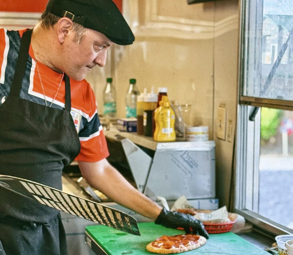 Un empleado de cocina prepara una pizza en el interior del Post Oak Beer Garden durante la inauguración oficial del local en San Juan.