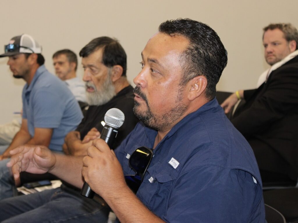 Ricardo De Anda de la Cruz habla por un micrófono durante una reunión sobre ganadería.