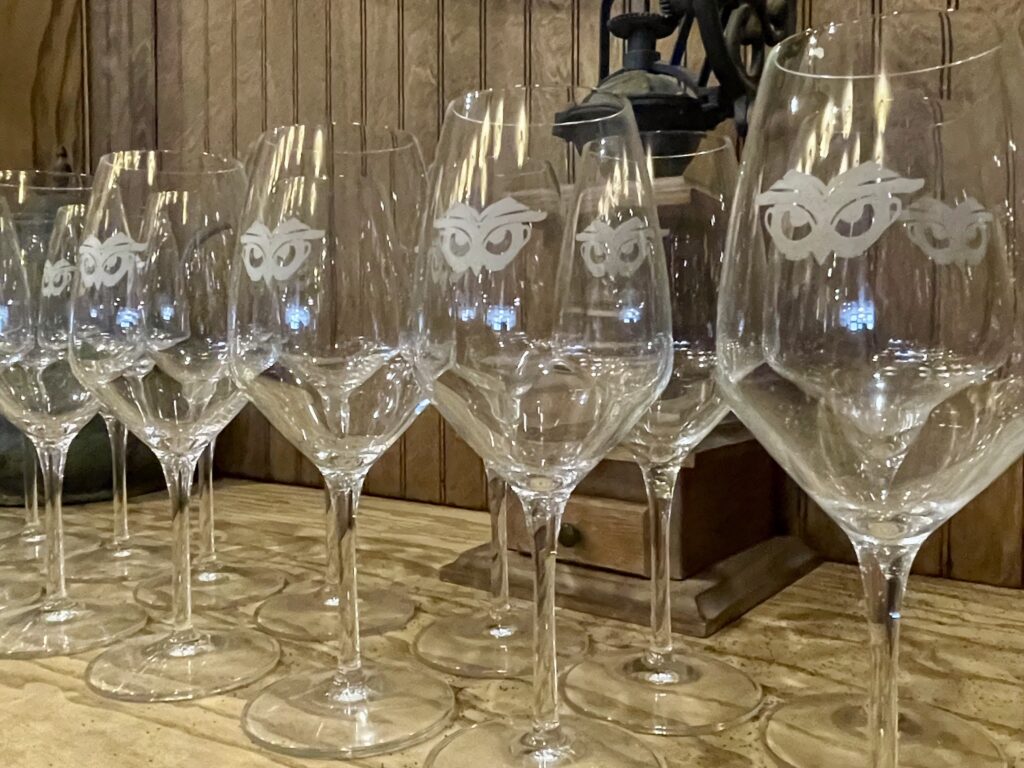 Las copas de vino grabadas con el logotipo del búho de Búho están dispuestas en una barra dentro de la cafetería, la tetería y la vinoteca de la librería.
