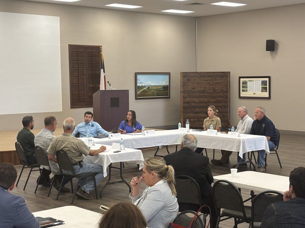 Farmers and federal officials sit around tables during an agricultural workforce roundtable at Rio Farms in Monte Alto.