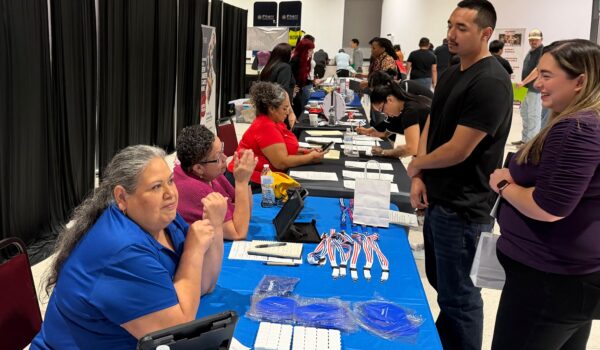 Job seekers speak with Walmart representatives during a Workforce Solutions job fair in Pharr, Texas.